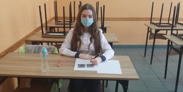 Uczennica Kamila Makarenko siedzi w ławce szkolnej i rozwiązuje zadanie konkursowe